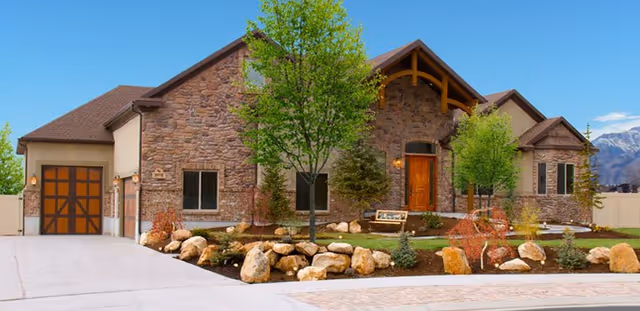 Stone exterior of Assisted Living of Draper with wooden entry door and landscaped front yard.