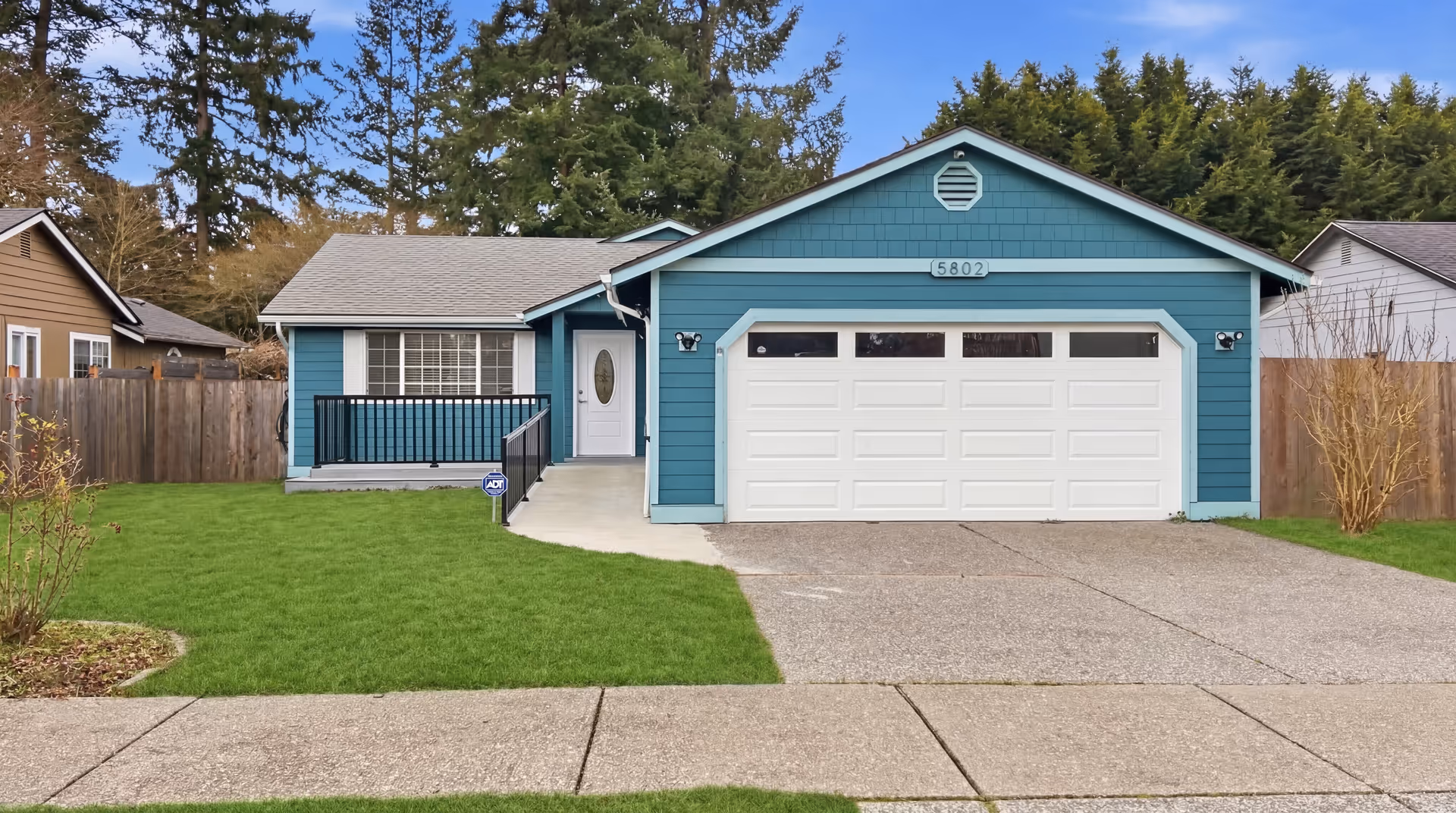 Front view of Nobel Adult Family Home: blue exterior with a two-car garage.