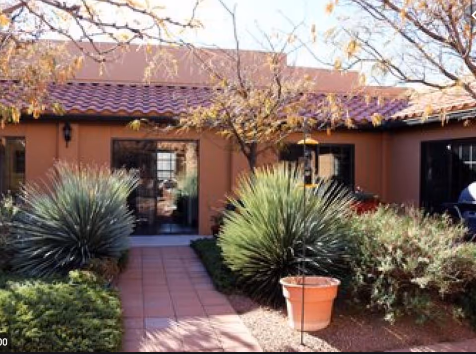 Exterior view of Carefree Assisted Living Center with a tiled walkway and desert landscaping.