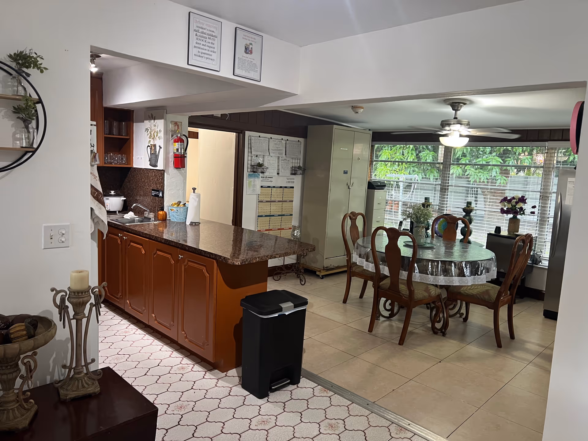 Open kitchen and dining area with a round table, kitchen island, and large windows.