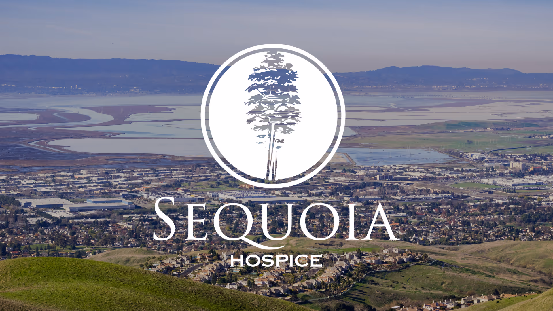 Aerial landscape view with a Sequoia Hospice logo overlay.