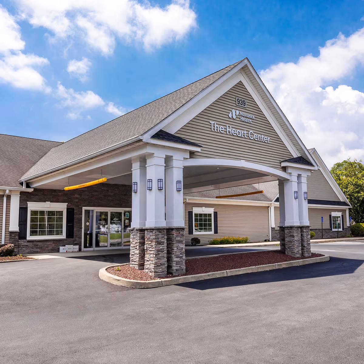 Exterior view of The Heart Center entrance with a peaked roof and stone columns.