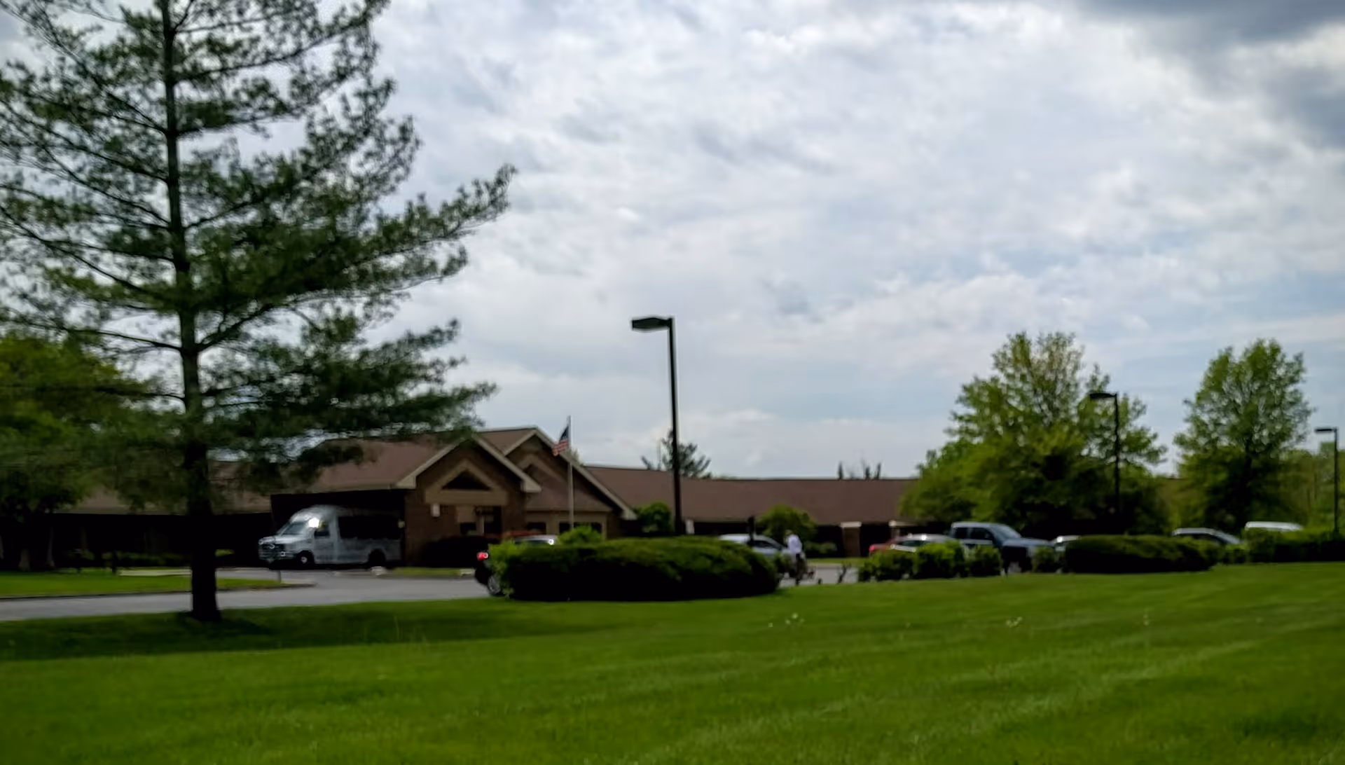 Front view of The Loft of East Peoria exterior with a green lawn and parked cars.