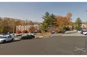 Exterior view of Envoy of Woodbridge with a parking lot and trees.