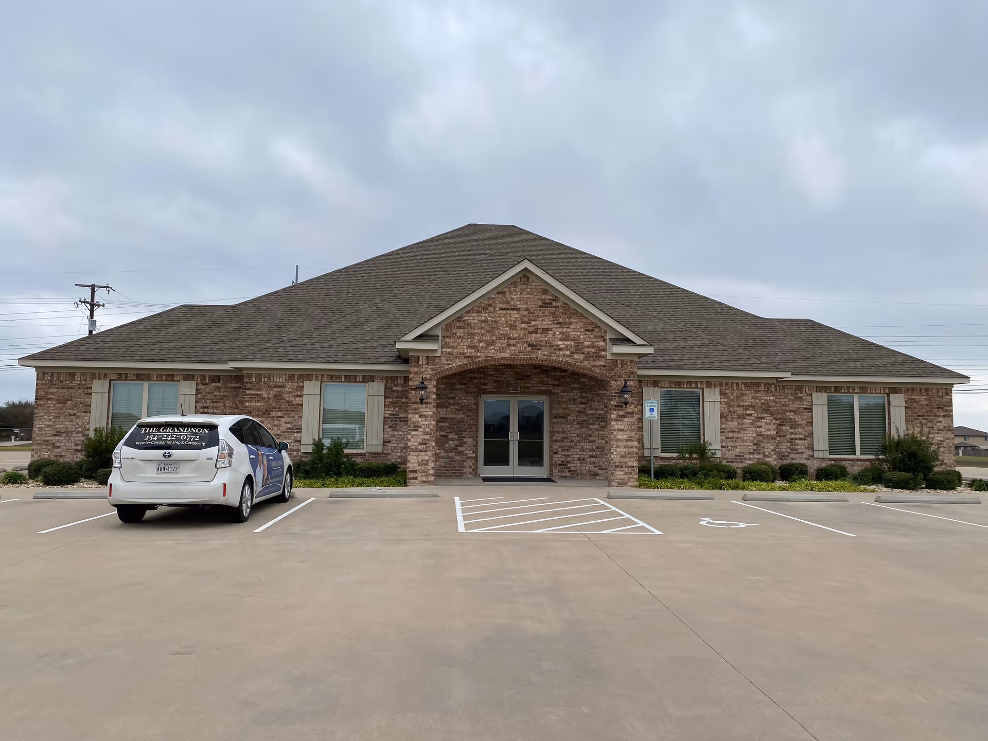 Single-story brick senior care facility with a parking lot and front entrance.
