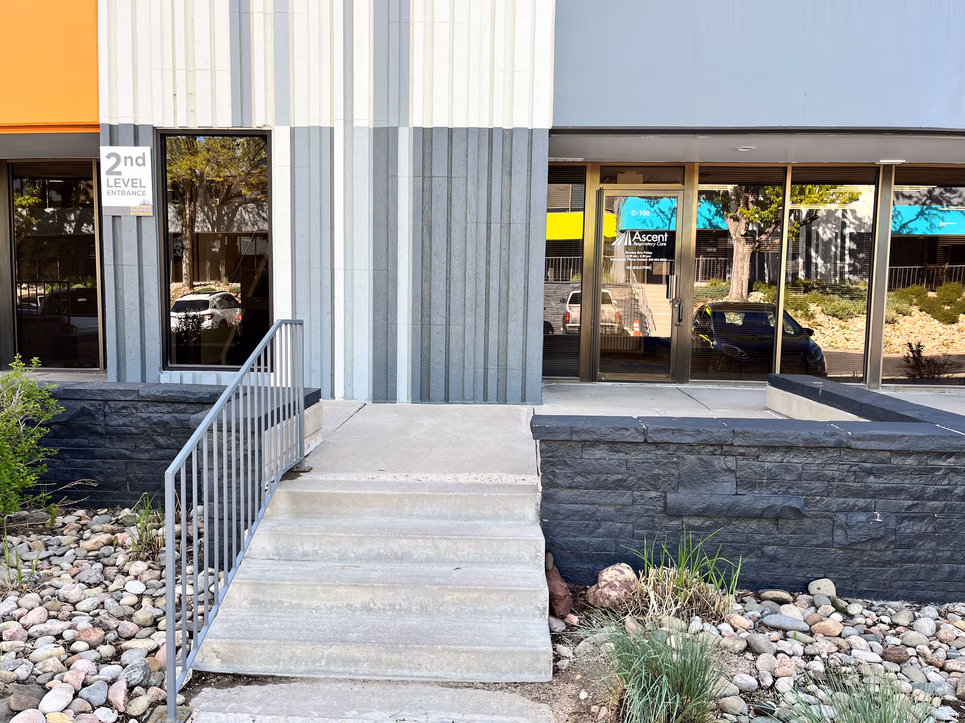 Exterior view of a modern building entrance with glass doors labeled Ascent Respiratory Care