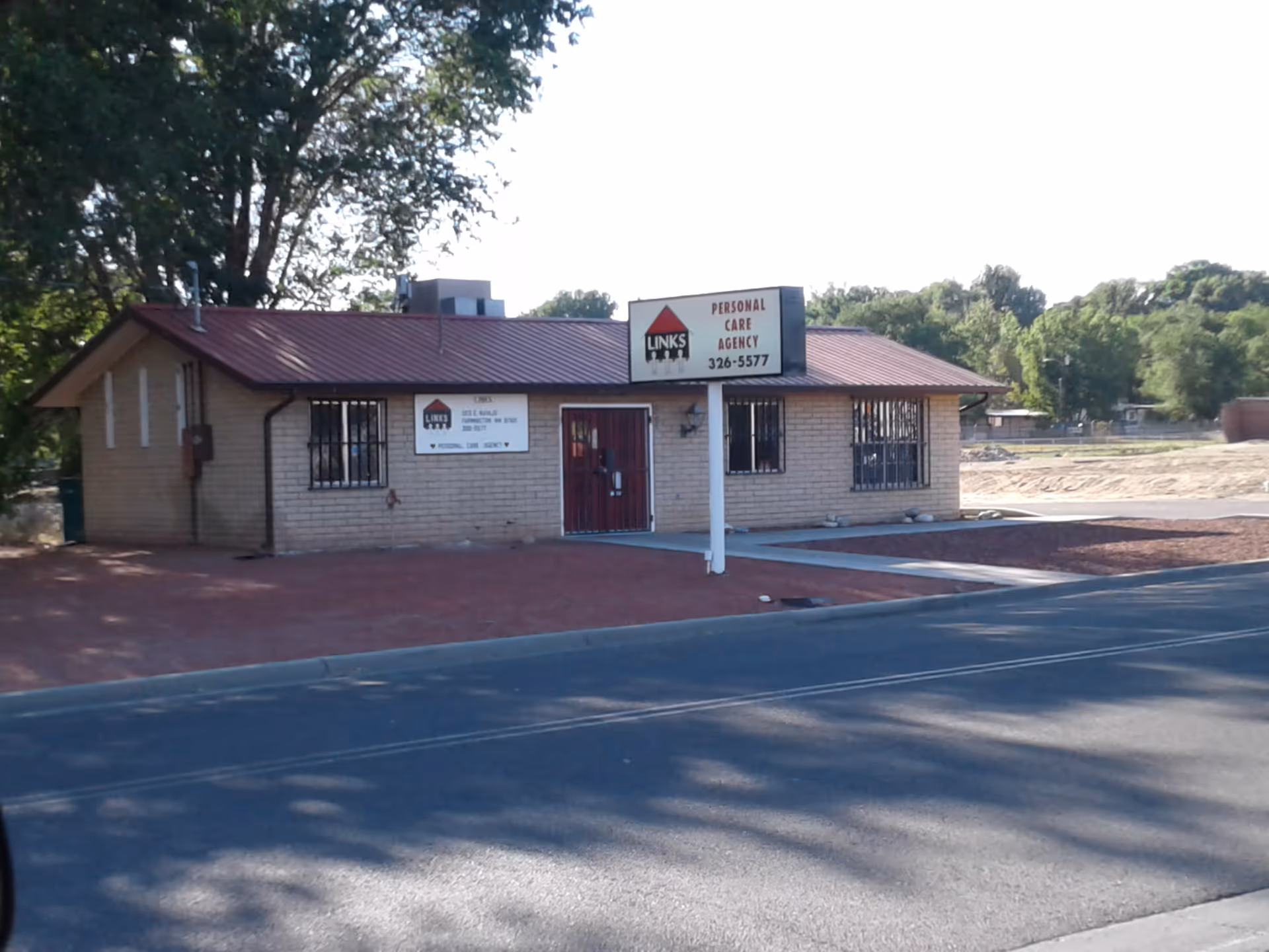 Small brick office building with red roof and a sign for Links II Personal Care.