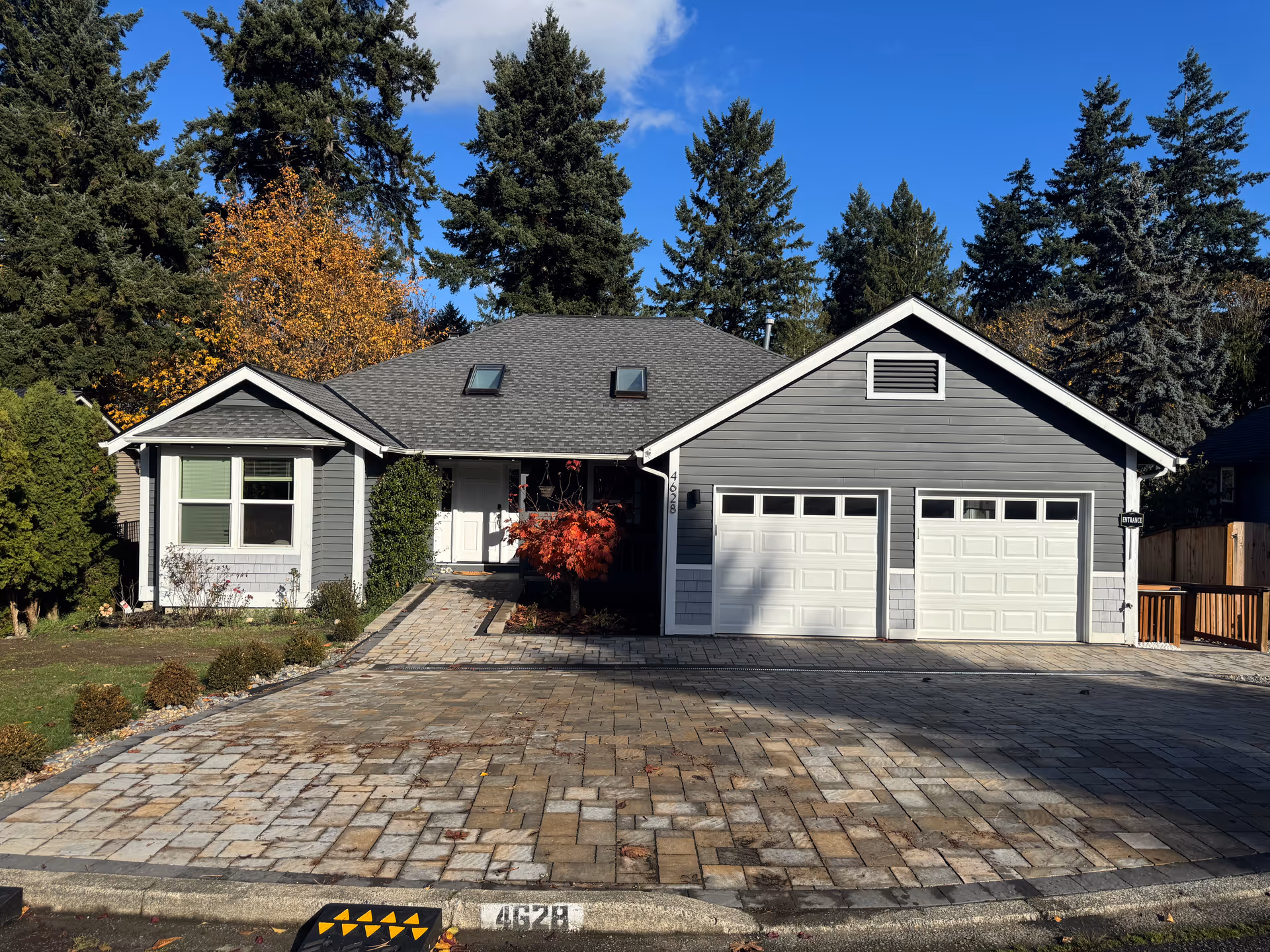 Residential single-story home with two-car garage and stone-paved front driveway