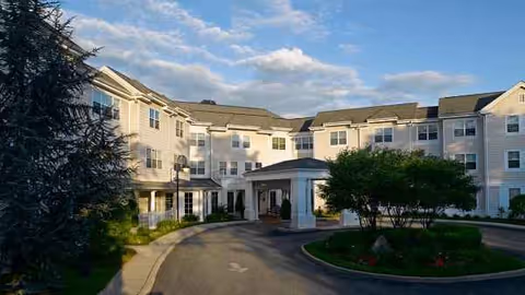 Atria Plainview senior living facility exterior with a circular driveway and manicured landscaping.
