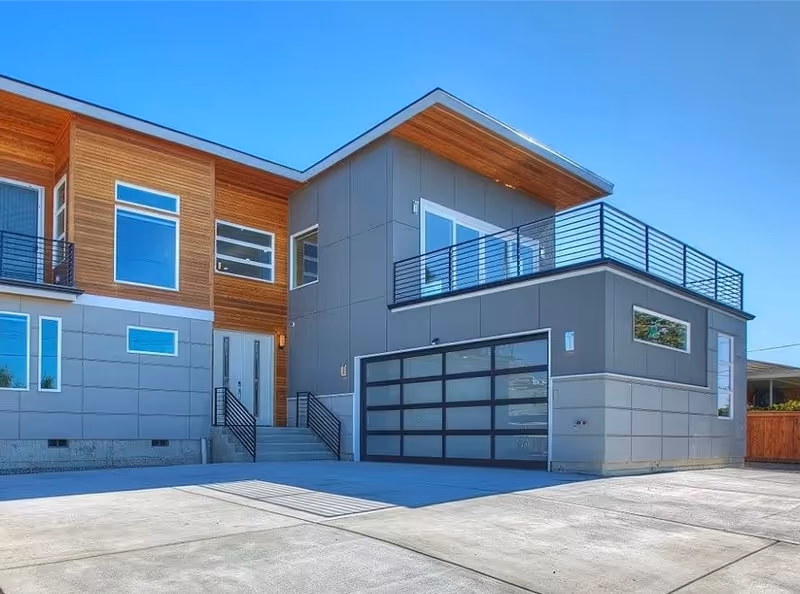 Modern exterior of Sunset care Home LLC, featuring a driveway, entry stairs, and upper balcony.