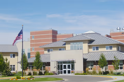 Exterior view of Centre Ave Health & Rehab facility with entrance, flagpole, and landscaping.