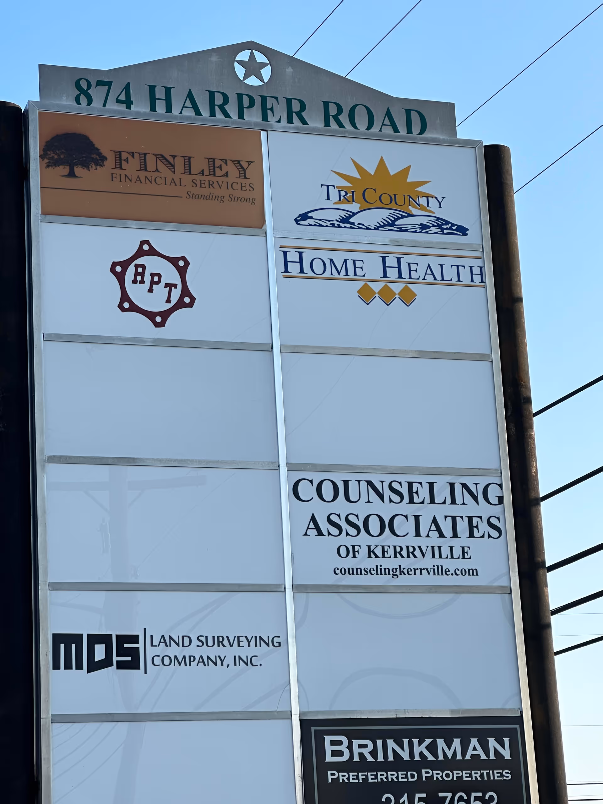 Tall outdoor signboard with multiple business logos at 874 Harper Road