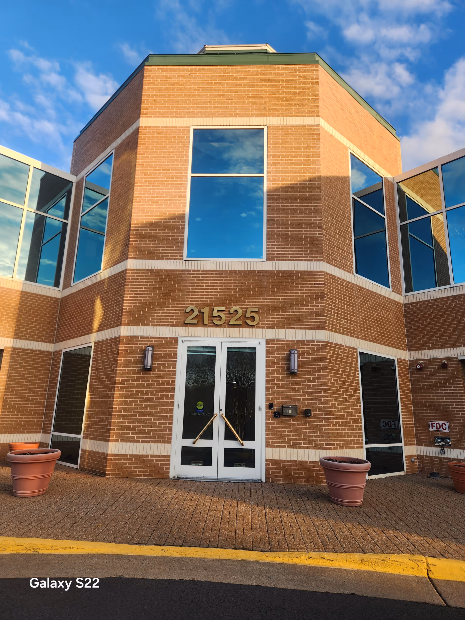Exterior brick building with glass doors, large windows, and the number 21525.