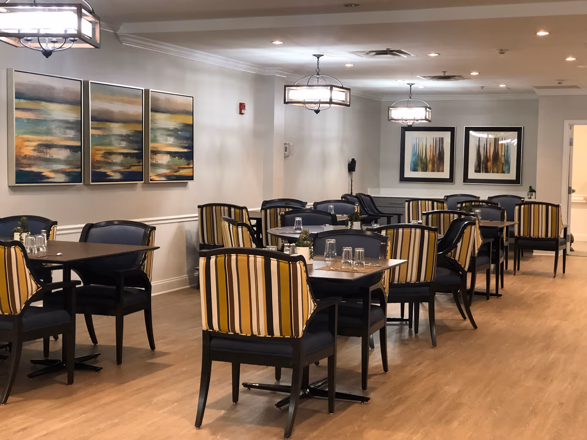Phoenix at Dunwoody dining room with tables, striped chairs, and wall art.