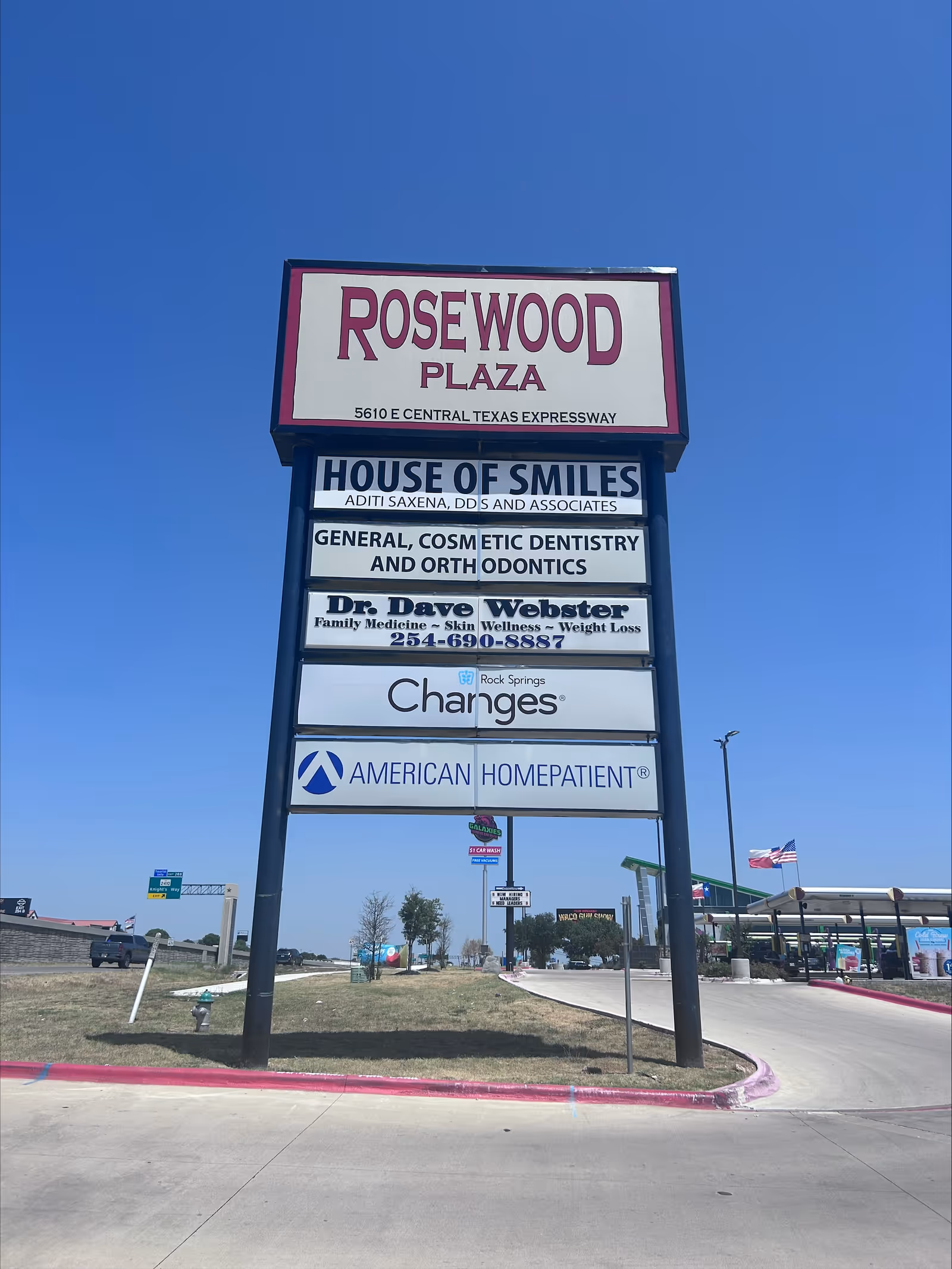 Tall outdoor plaza sign displays Rosewood Plaza with American HomePatient branding.
