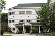 Exterior view of Springbrook Center's multi-story front entrance with a covered porch and landscaping.