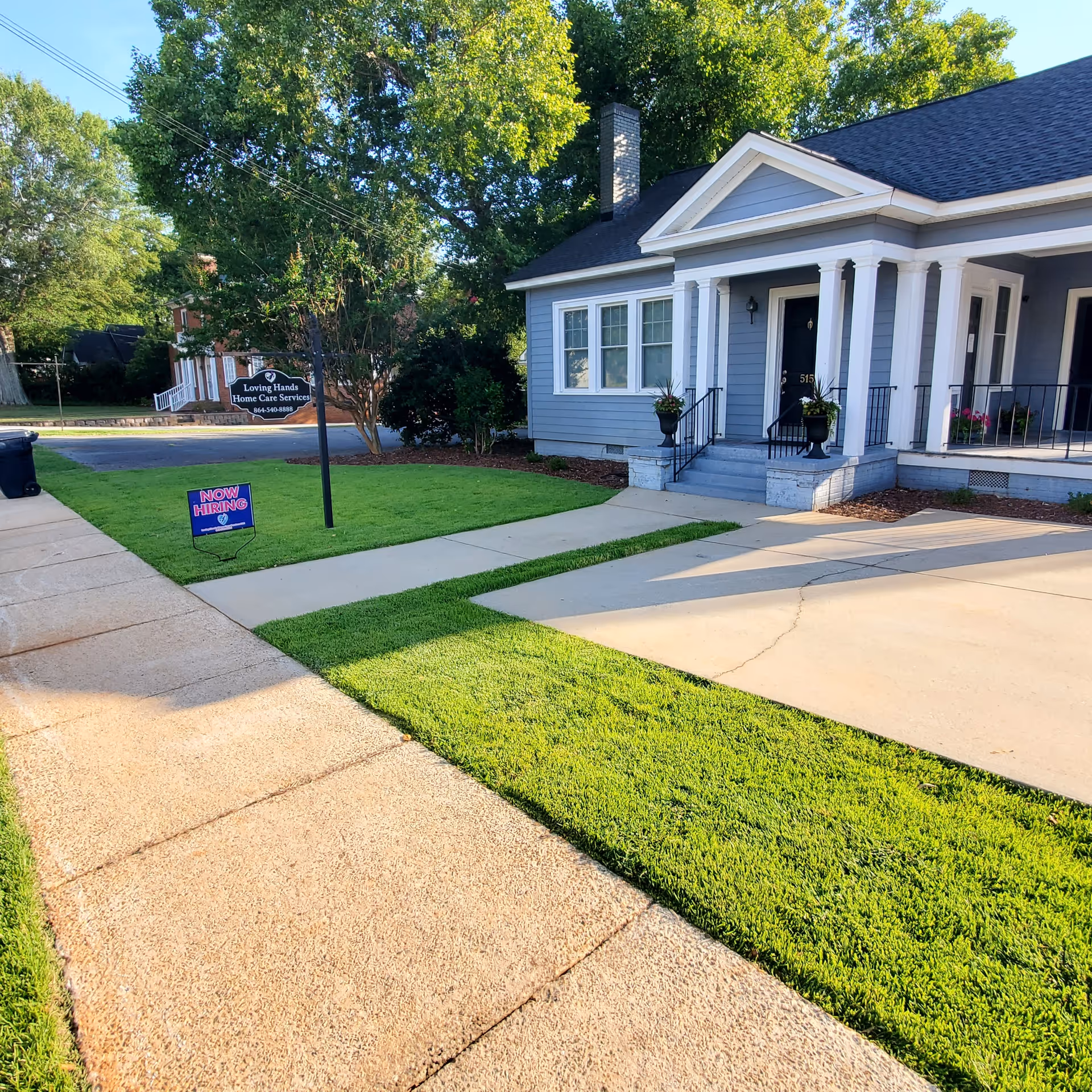 Front exterior of Loving Hands Home Care Services facility with lawn and sign