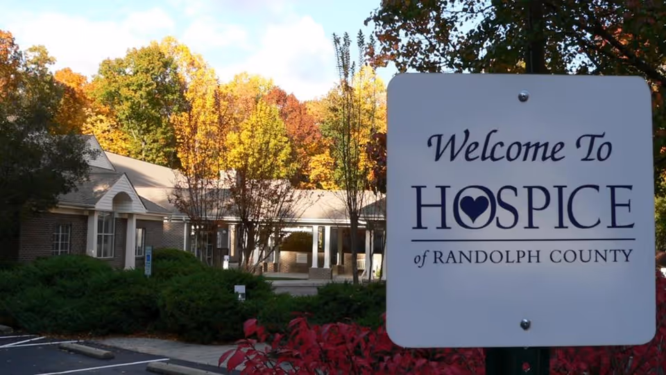 Exterior view of Hospice of Randolph County with entrance and fall-colored trees.