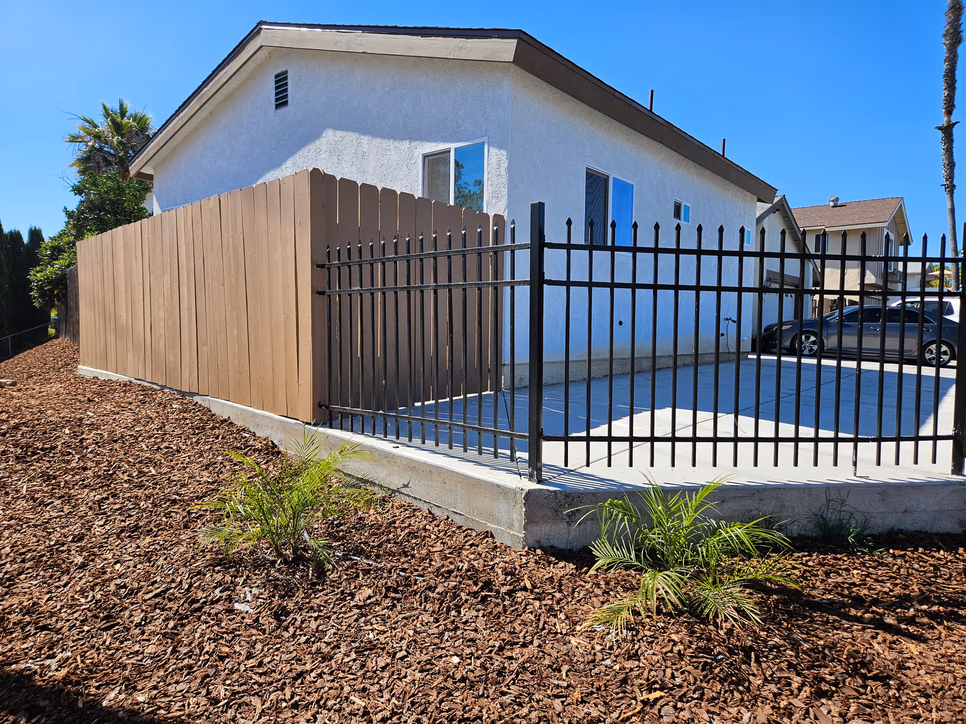 Exterior of Silverado Senior Living Escondido with a black metal fence and gated driveway.