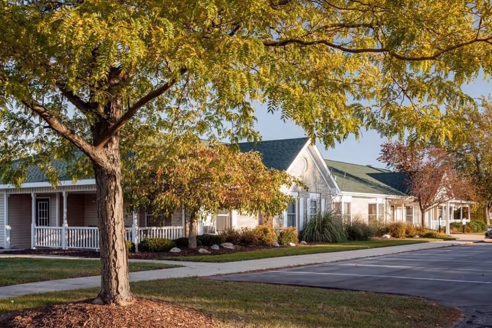 Front exterior of Addington Place of Lakeside Vista with trees and parking.