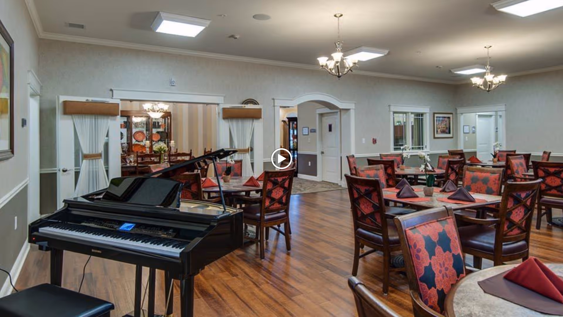 Spacious dining room with multiple set tables and a grand piano in the foreground.