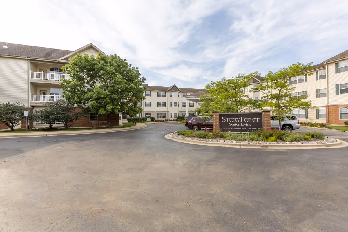 StoryPoint Libertyville Senior Living exterior with sign, drive, and trees.