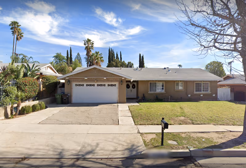 Single-story beige house with a two-car garage and front yard.