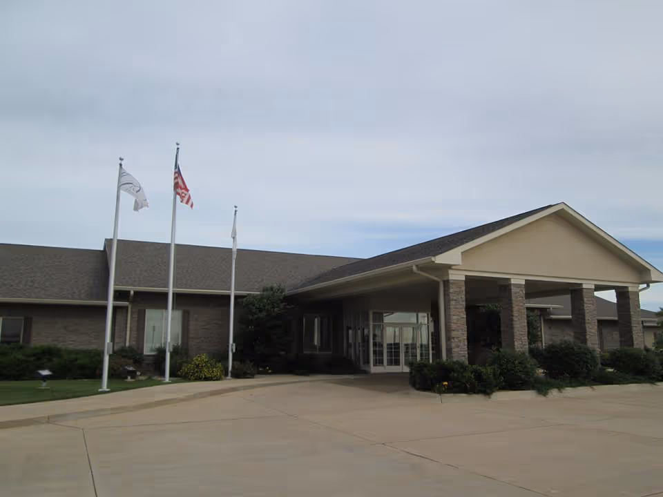 Exterior view of Courtyard Estates of Bushnell with entrance canopy and flagpoles.