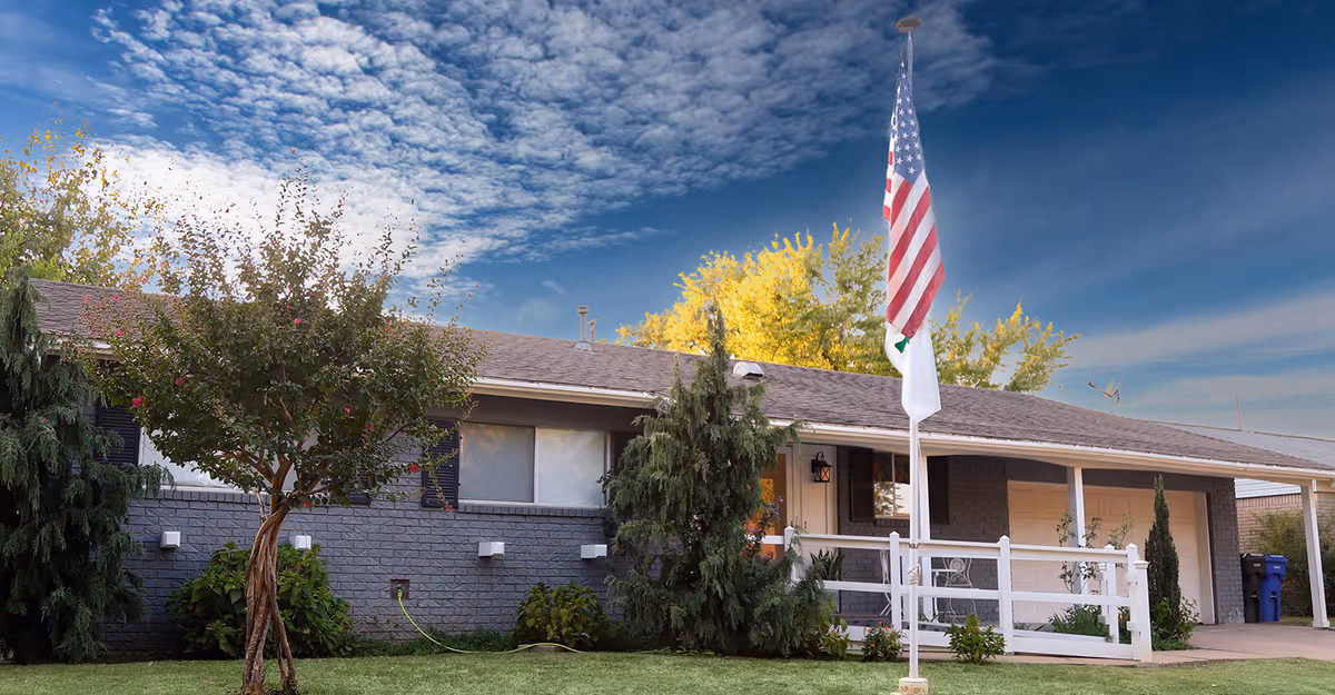 Single-story assisted living facility exterior with front yard and flag