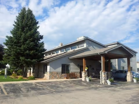 Exterior view of Faith Living Center with covered entrance, stone pillars, and parking.