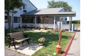 Exterior view of Cedars of Lebanon senior living facility with a covered front porch and bench