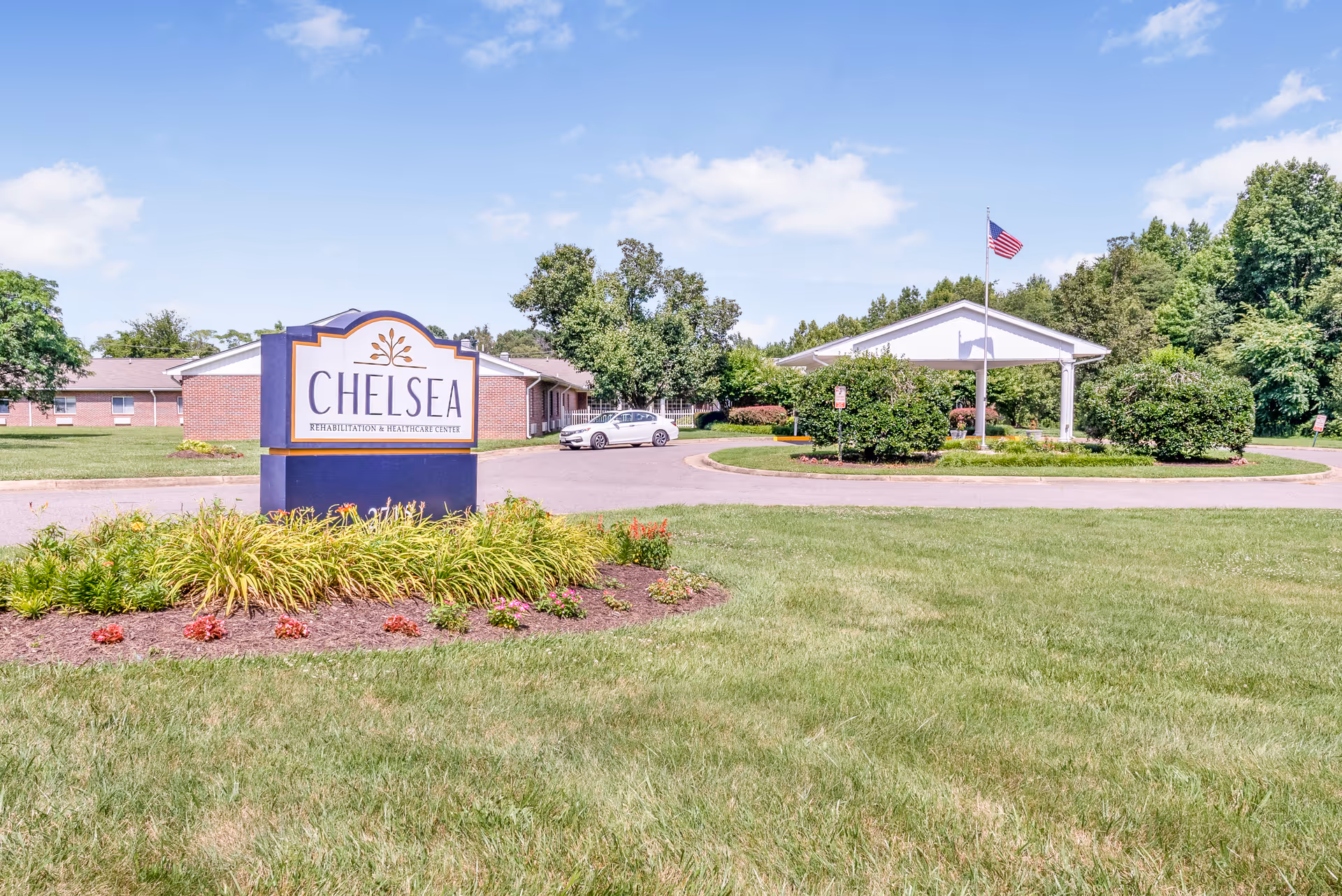 Exterior view of a nursing center with a large sign and landscaped grounds.