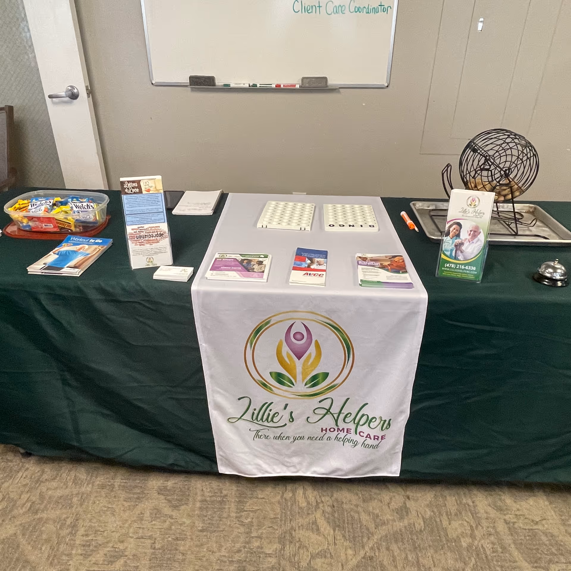 Indoor care booth setup with brochures and banner for Lillie's Helpers Home Care