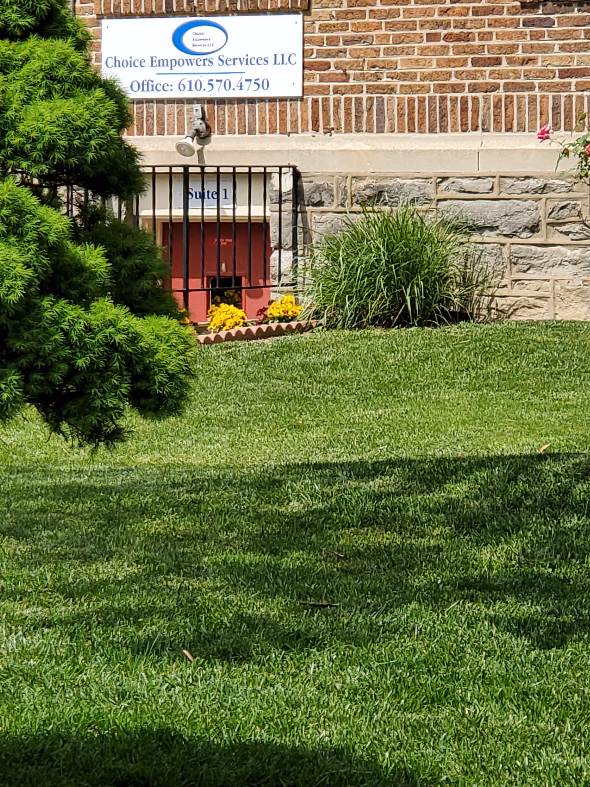 Exterior view of Choice Empowers Services LLC building with sign, lawn, and landscaping.