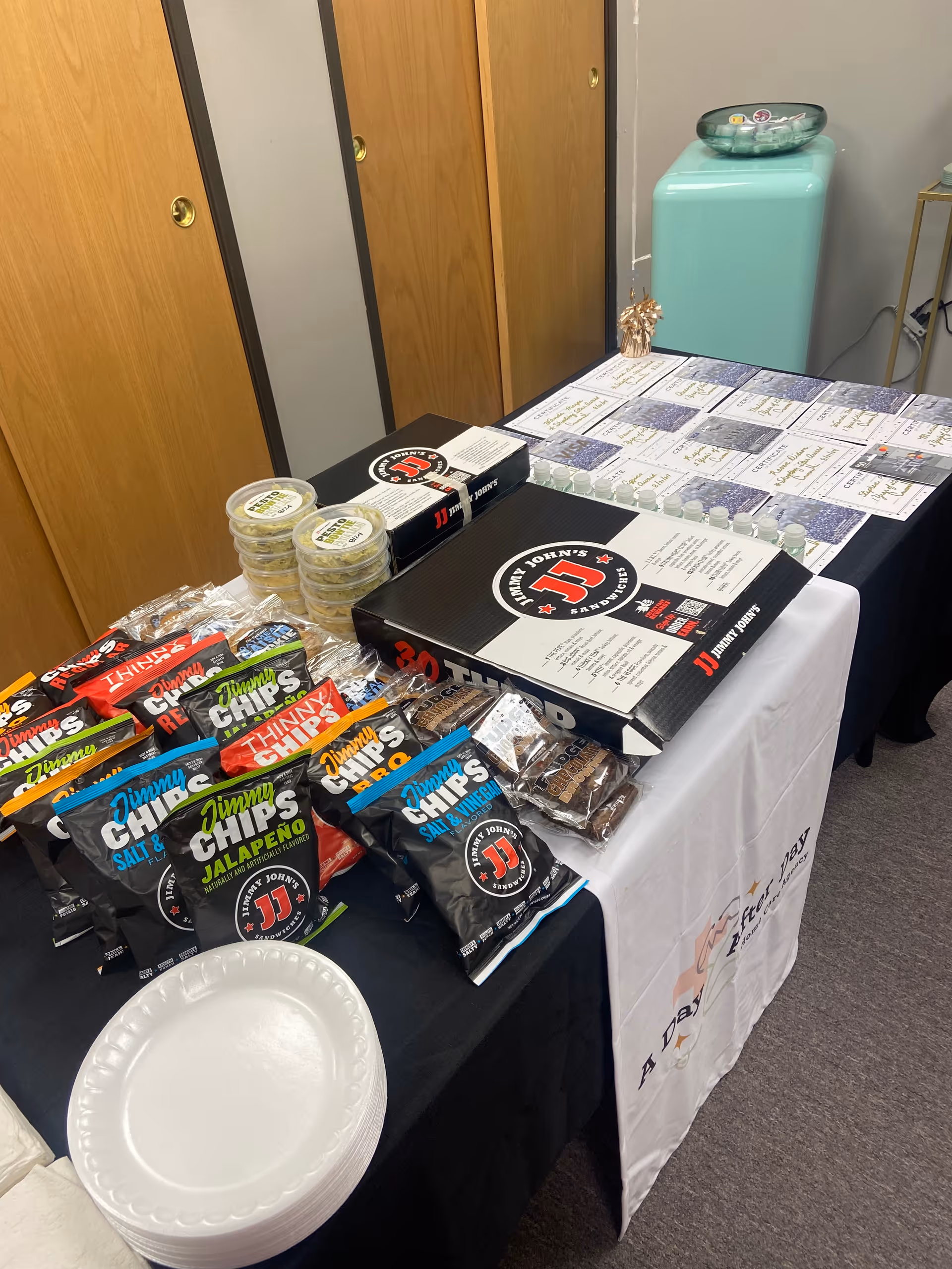 Table display of snacks and promotional boxes arranged in an interior room.