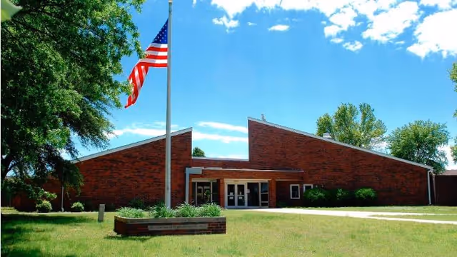 Exterior view of The Wolfe Living Center at Summit Ridge, brick front with flagpole and entrance.