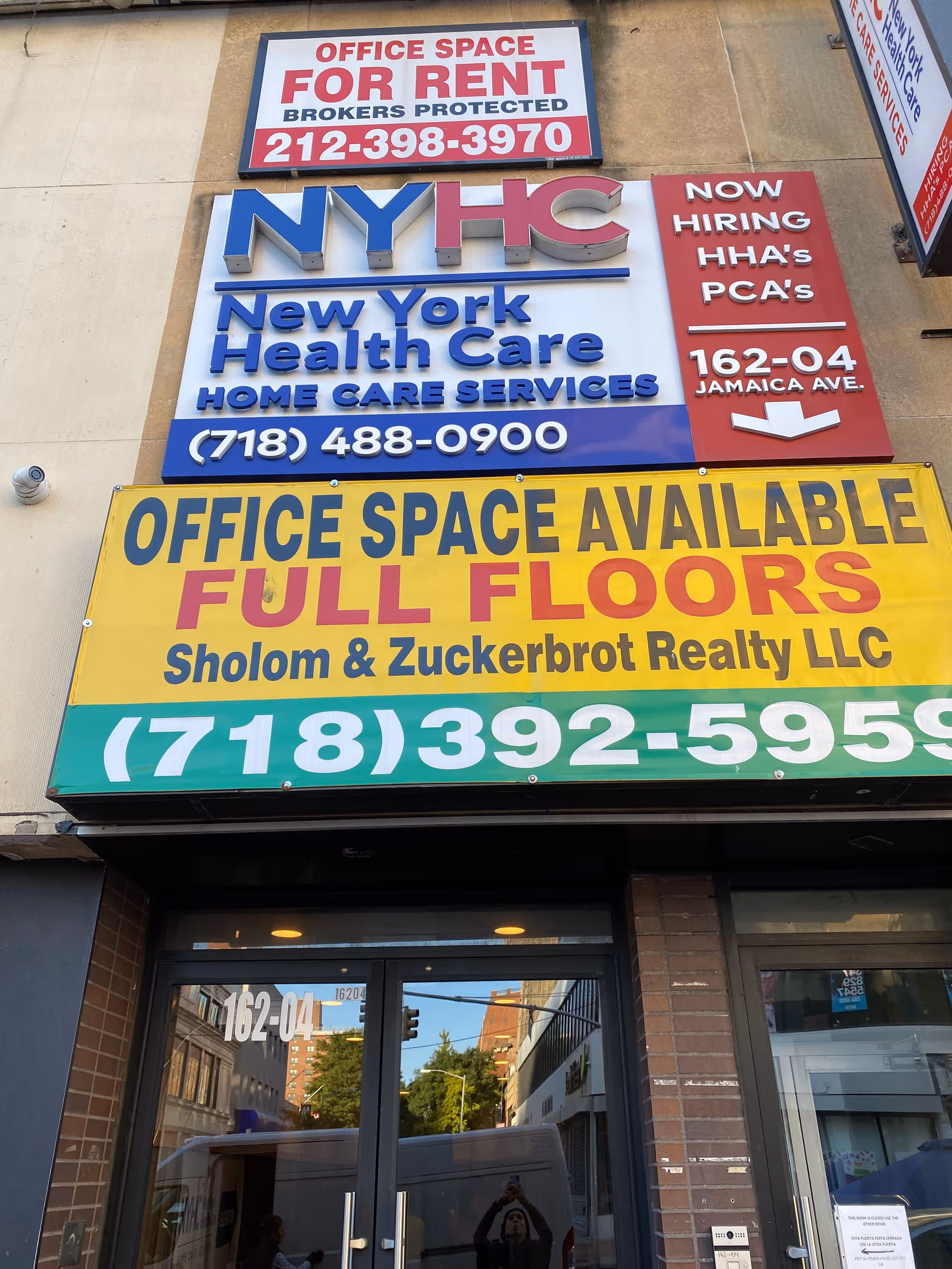 Exterior storefront with NYHC sign for New York Health Care and office-for-rent banners.