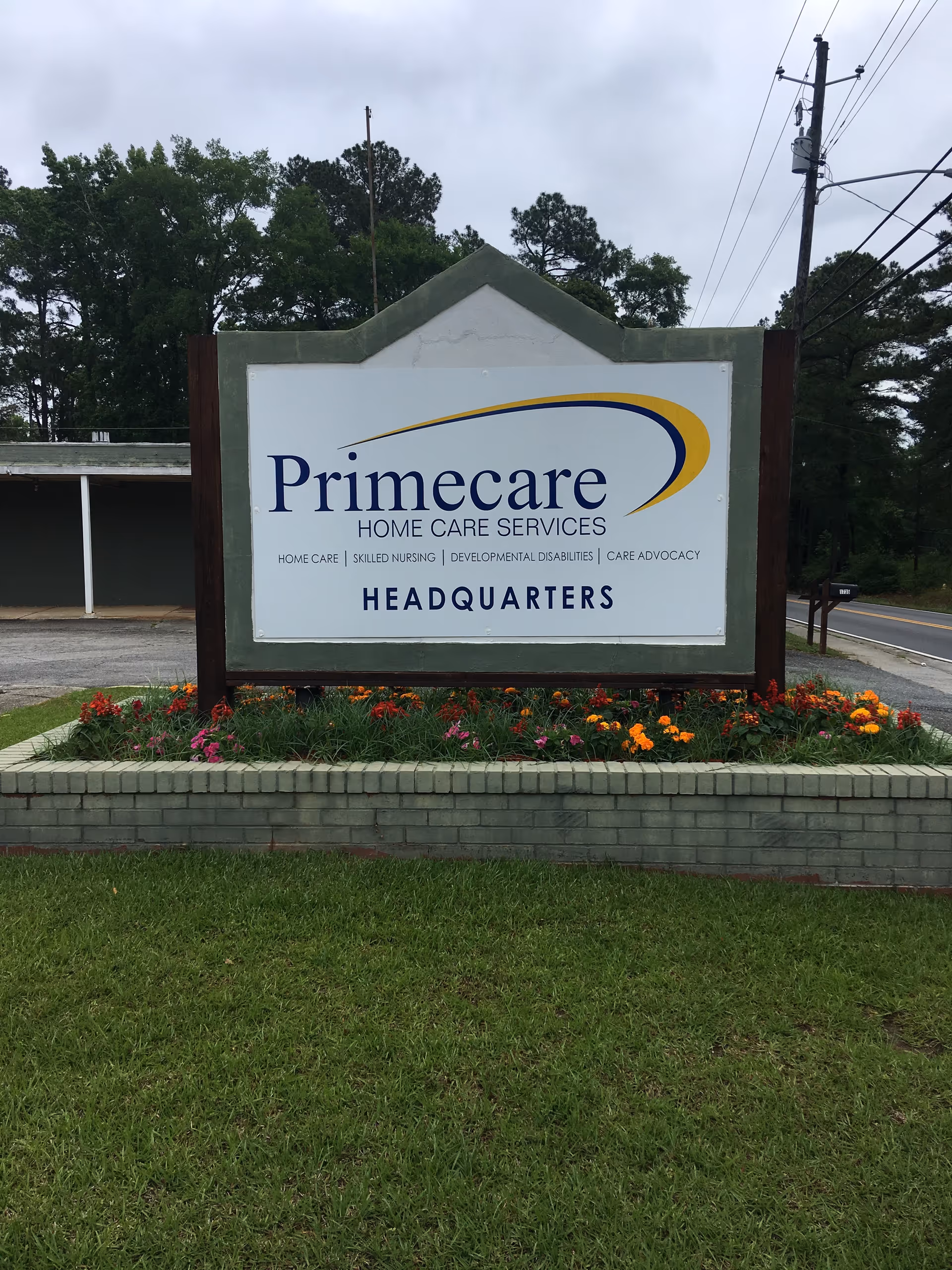 Primecare Home Care Services headquarters sign displayed in a landscaped garden.