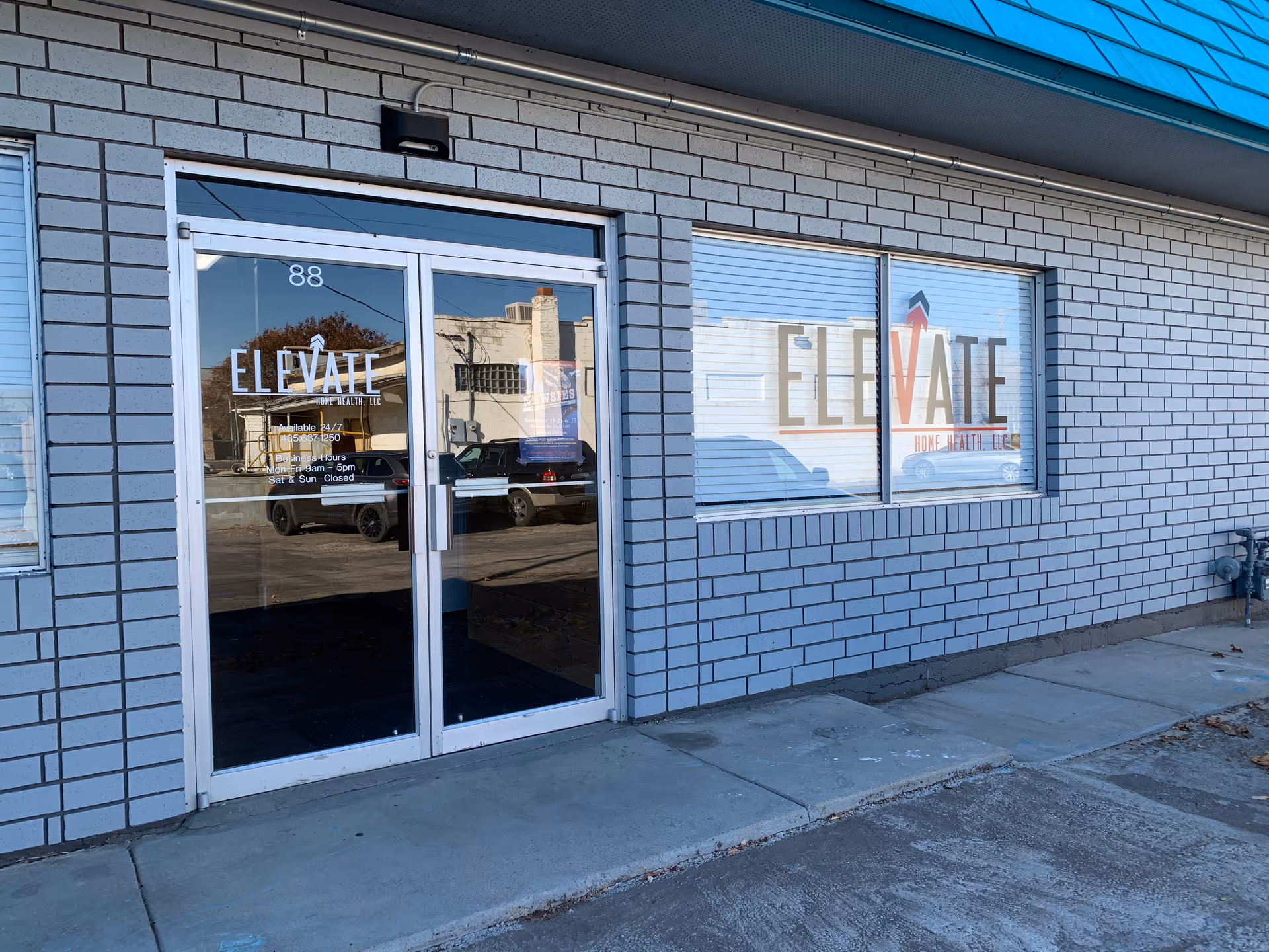 Brick storefront with glass doors and windows displaying Elevate Home Health and Hospice signage