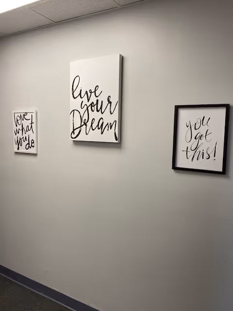 Hallway wall featuring three framed inspirational prints, including 'Live your dream'.