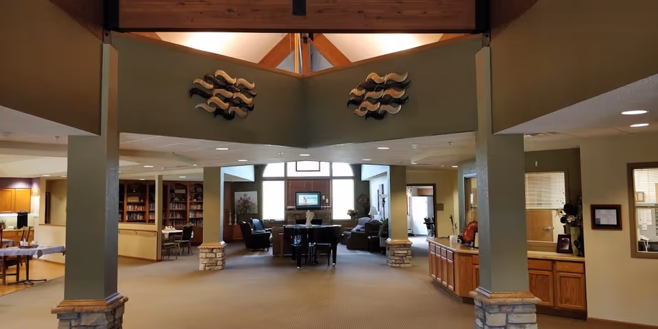 Spacious lobby of Good Samaritan Society Albert Lea with seating, bookshelves, and a front desk.