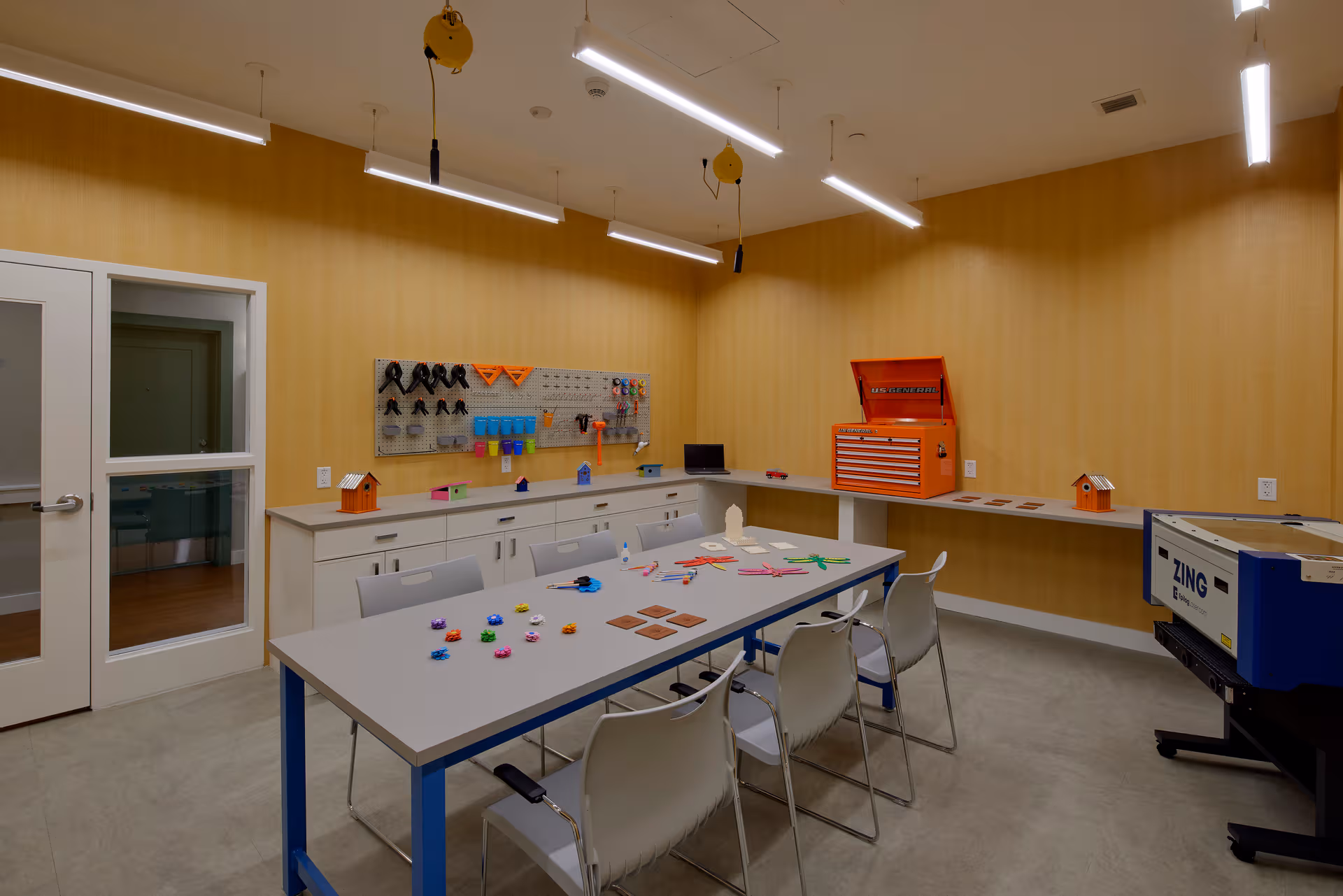 Bright craft workshop at The Cordwainer with tables, tools, and organized storage.