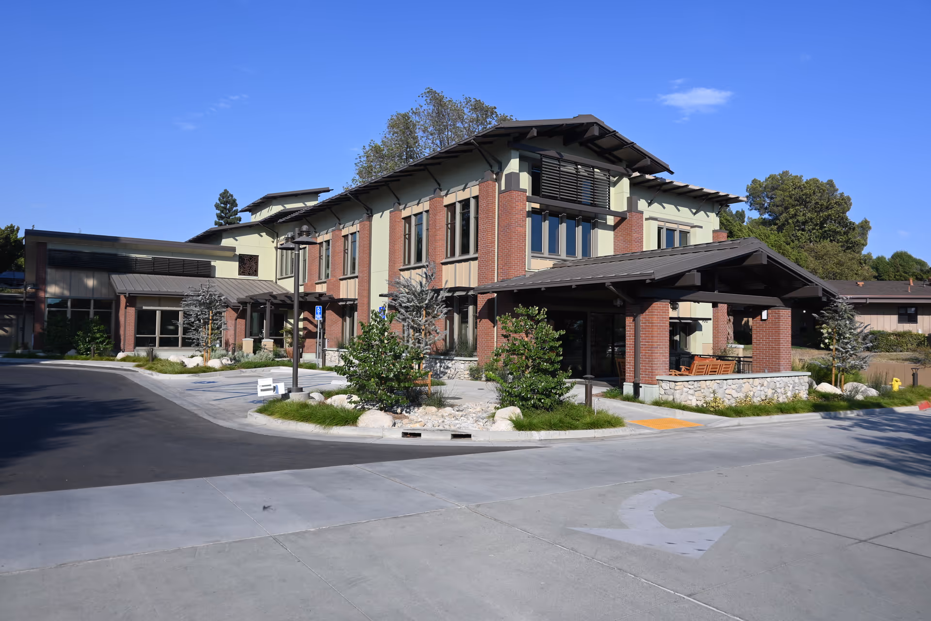 Exterior view of Mount San Antonio Gardens, showing the brick building, entrance, and landscaped driveway.