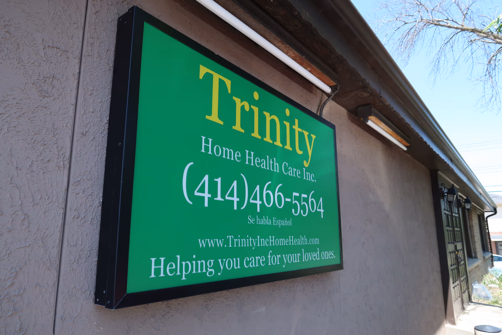 Large green Trinity Home Health Care sign mounted on the exterior wall of a building.
