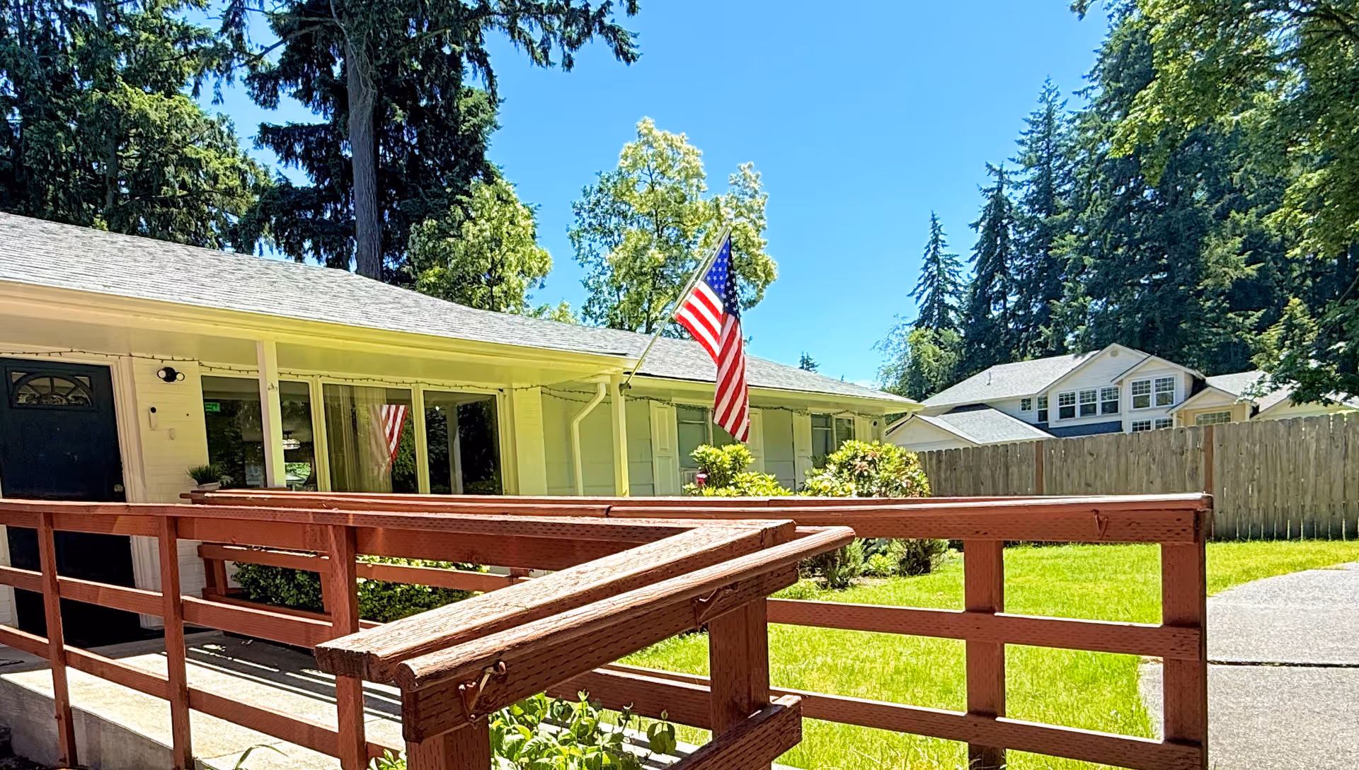 Exterior view of a single-story facility with ramp, flag, and green lawn.
