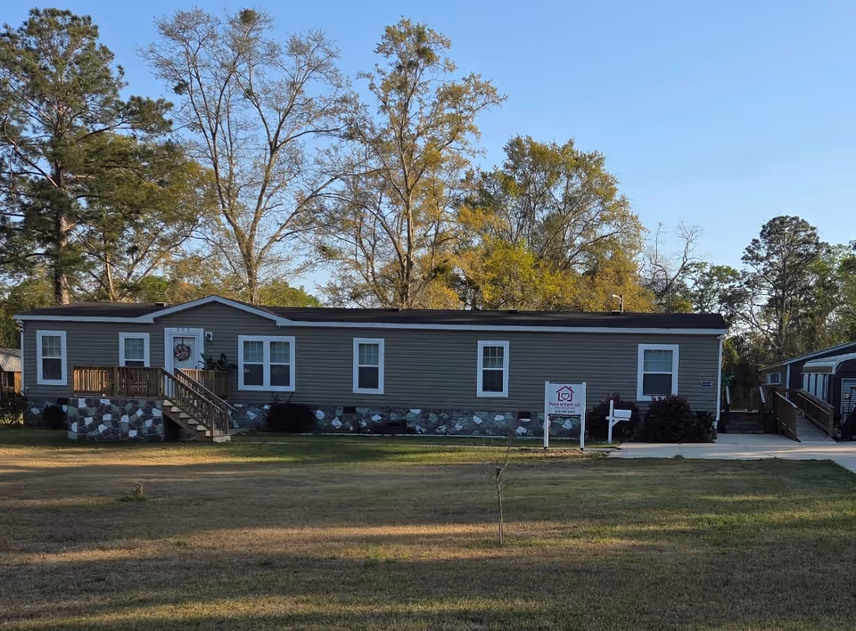 Single-story beige building with stone foundation, front porch, and Peace on Earth LLC sign.