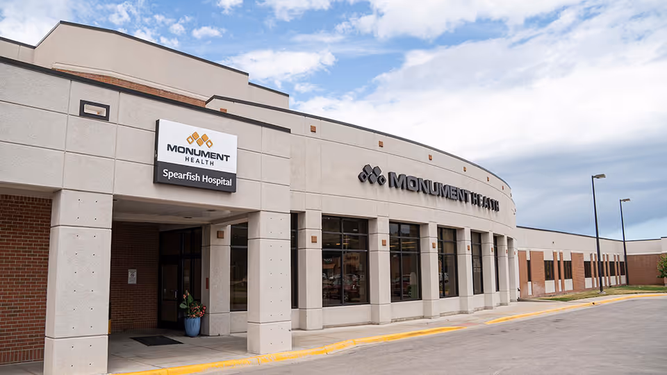 Exterior view of Monument Health hospital building with signage and large windows.