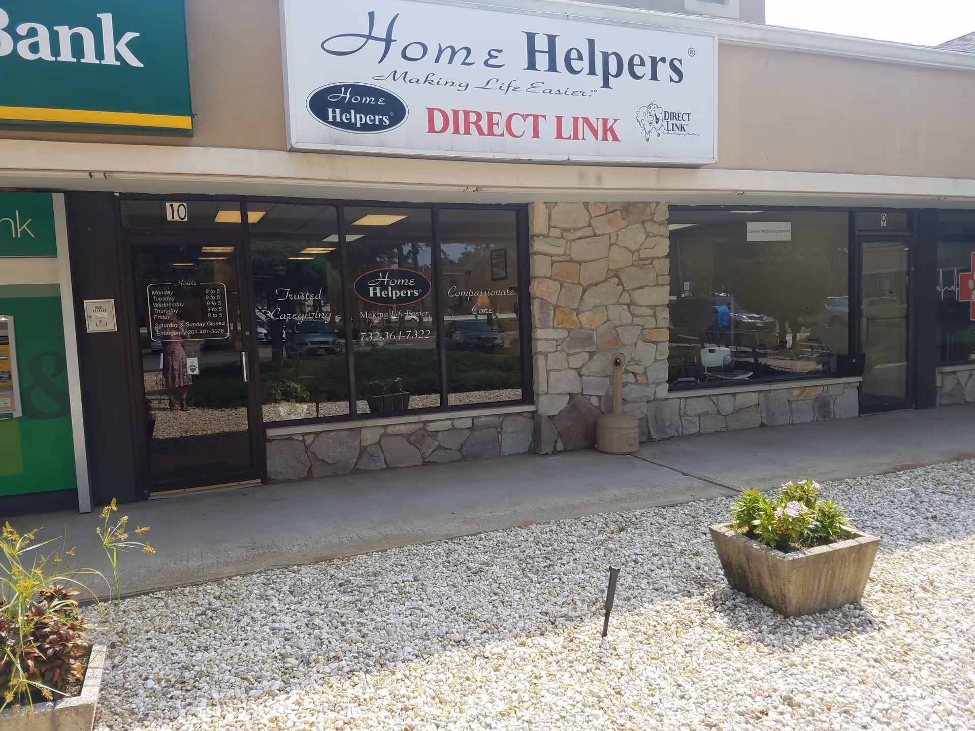 Exterior storefront of Home Helpers and Direct Link with stone facade and gravel landscaping.
