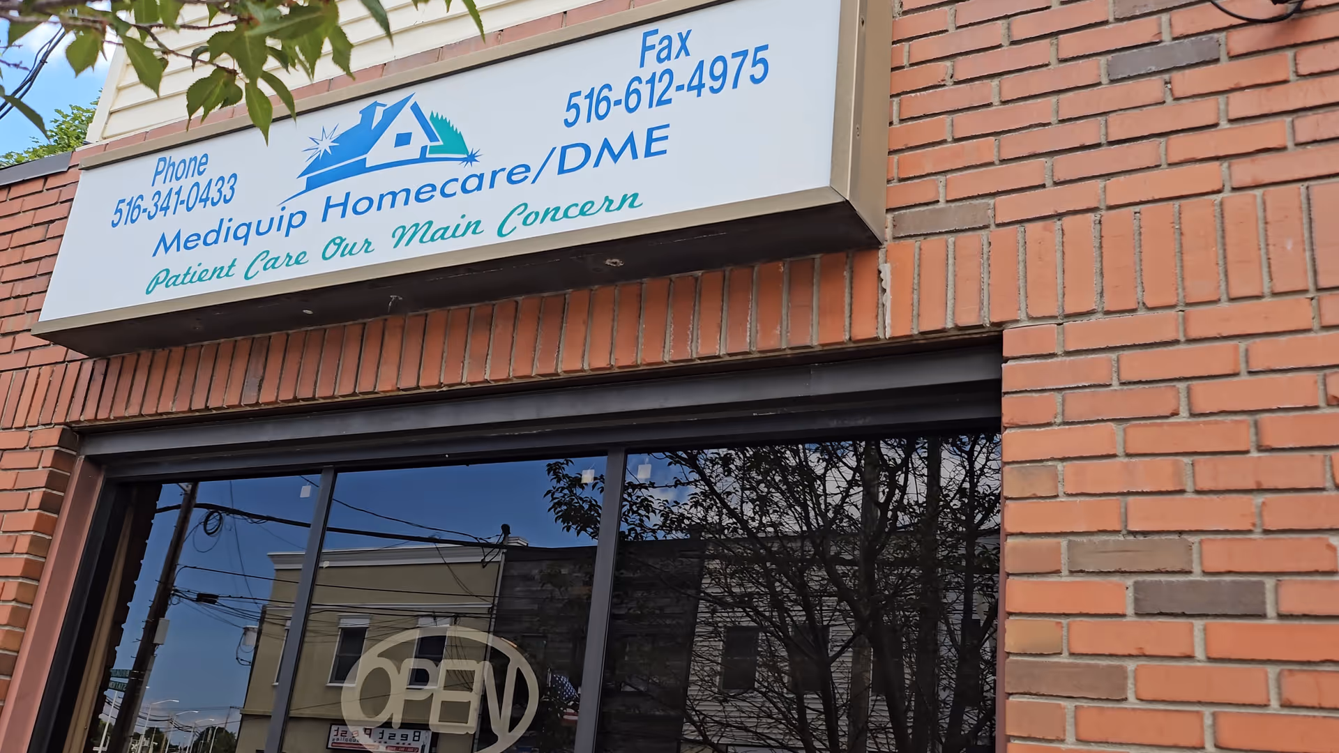 Brick storefront with Mediquip Homecare/DME sign and an OPEN window sign.