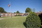Front view of Senior Rehab & Recovery Center at Limestone Health Facility with flag and lawn.